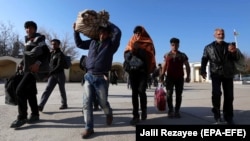 Afghan refugees cross the border into Afghanistan's Nimroz Province after they were deported by Iran. (file photo)