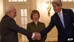 Iranian Foreign Minister Mohammad Javad Zarif (left) shakes hands with U.S. Secretary of State John Kerry (right) as EU envoy Catherine Ashton looks on at nuclear talks on November 20.