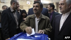 Iran's new election law is seen by some as the outcome of a power struggle between President Mahmud Ahmadinejad (center) and Supreme Leader Ayatollah Ali Khamenei.