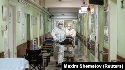 Medical workers move a patient on a trolley inside a hospital where patients suffering from COVID-19 are treated in Moscow.