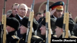 Russian President Vladimir Putin (left) and Defense Minister Sergei Shoigu watch a guard of honor passing by as they take part in a wreath-laying ceremony marking Defender of the Fatherland Day in Moscow. (file photo)