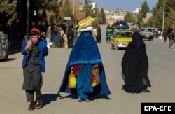 Afghan families receive food aid distributed by the German government in Kabul in December.