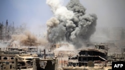 Smoke rises following an air strike on a rebel-held area in Syria. According to one commander, a Russian officer "coordinates the air cover" with mercenary troops on the ground. "Sometimes it is a thing of beauty to see how perfectly the aviation and artillery support works out," he says. (illustrative photo)