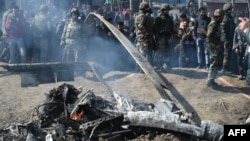 Indian soldiers and Kashmiri onlookers stand near the remains of an Indian Air Force aircraft after it crashed in the Budgam district, some 30 kilometers from Srinagar on February 27. 