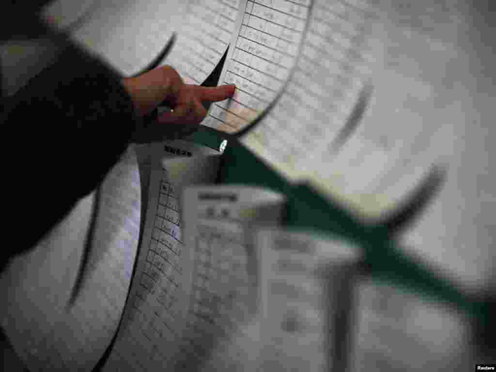 A survivor looks through names displayed in a collection center for evacuees in Otsuchi on March 15