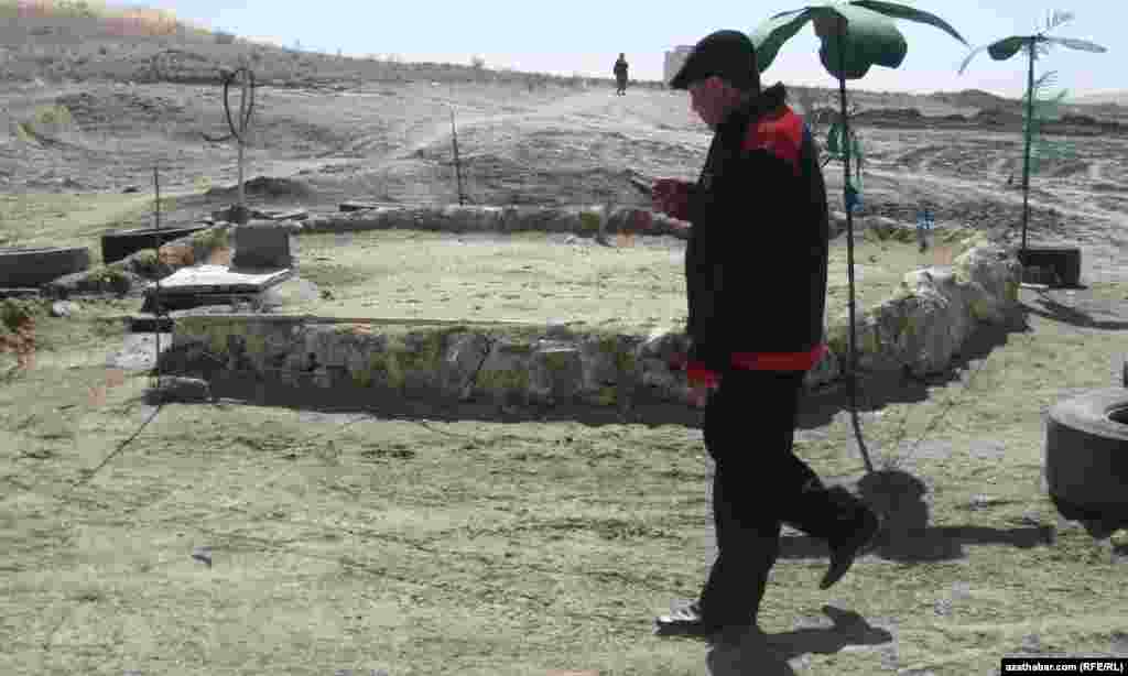 A man checks his mobile telephone as he walks through a remote Yerbent village in Turkmenistan&#39;s Karakum Desert.