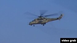 A helicopter flies over Anbar Province during Iraqi military air strikes.