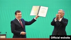 Shavkat Mirziyaev (left) is sworn as Uzbek president at a joint session of the parliament's two chambers in Tashkent on December 14. 