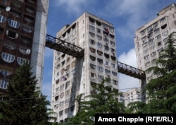 Apartment blocks in a hilly Tbilisi suburb with a dizzying “skybridge” that allows people to take an elevator up to the apartment on the left and then walk across to a hilltop grocery store