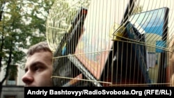 Man holding "cage with Ukrainian Films" during a protest against the new language bill 