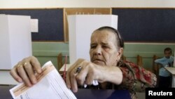 A woman casts her vote at a polling booth in the village of Vrapcici near Mostar 