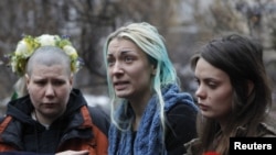 Activists from the Ukrainian women's rights group Femen hold an impromptu press conference on their return to Kyiv (from left to to right: Aleksandra Nemchinova, Inna Shevchenko, and Oksana Shachko). 