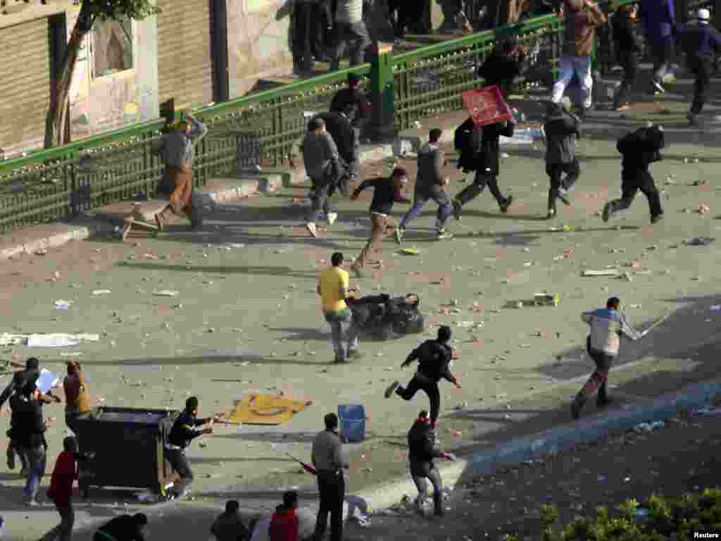 An antigovernment protester falls as Mubarak supporters clash with demonstrators occupying Tahrir Square.