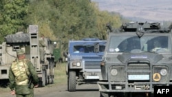 Members of the EU Monitoring Mission man a checkpoint.