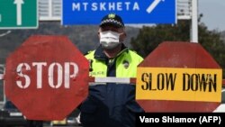 A Georgian policeman stands guard at a checkpoint in Tbilisi on April 1.