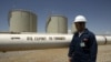 A worker stands next to an export pipeline at the Tawke oil refinery near the village of Zacho in Iraq's autonomous region of Kurdistan.