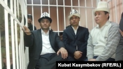 Opposition deputies Kamchybek Tashiev, Sadyr Japarov, and Talant Mamytov (left to right) in the dock at the start of their trial in Bishkek on January 10.