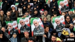 Mourners in Mashad hold placards depicting Qasem Soleimani on January 5