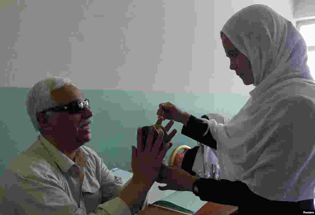 A teacher, who is also blind, teaches students at the school.