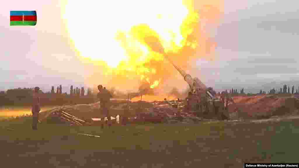 A still image from a video released by Azerbaijan&#39;s Defense Ministry shows members of the Azerbaijani armed forces firing artillery in an unidentified location.