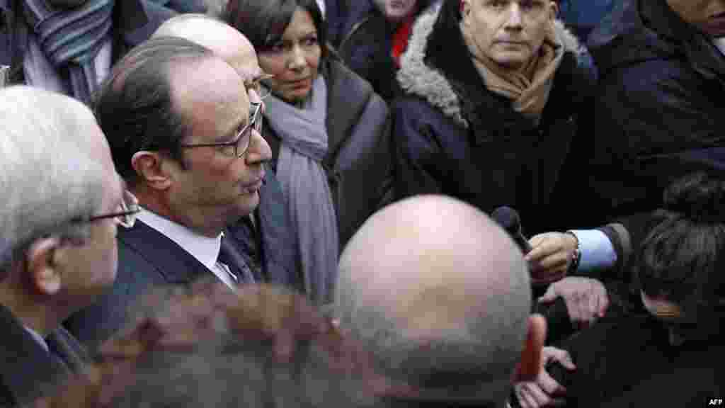 French President Francois Hollande speaks to the press after arriving at the Charlie Hebdo offices.