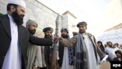  A Taliban militant hands over his weapons in Herat. Can the new incentives persuade more insurgents to lay down their arms? 