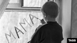 A boy in a Russian orphanage writes the word "mother" on a window pane. 