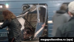 People gather in front of a damaged train door shortly after an explosion in St. Petersburg's subway on April 3.