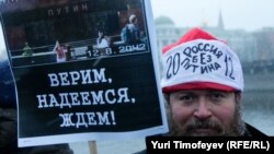 One of the tens of thousands of Moscow protesters holds a sign saying: "We believe, we hope, we wait!" His hat says: "Russian without Putin" 2012. 