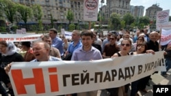 People shout slogans as they hold placards and a banner reading "No gay parade!" during an antigay rally in Kyiv on May 14.