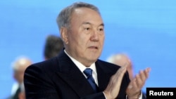 Kazakh President and presidential candidate Nursultan Nazarbaev applauds as he attends a session of the Assembly of People of Kazakhstan in Astana on April 23.