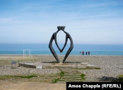 A Georgian family walks along the nearly empty beachfront of Batumi.