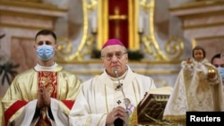 Archbishop Tadeusz Kondrusiewicz (center) conducts a service on Christmas Eve at a cathedral in Minsk on December 24. 