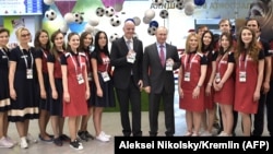 Russian President Vladimir Putin (center-right) and FIFA President Gianni Infantino (center-left) pose with their FAN IDs for the 2018 FIFA World Cup Russia at a distribution center in Sochi on May 3.