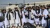 Taliban spokesman Zabiullah Mujahid (center, with shawl) speaks to the media at the airport in Kabul on August 31.