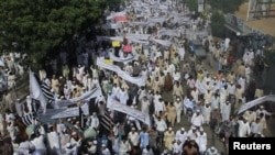 Pakistani protesters hold banners and flags while taking part in an anti-American protest rally in Karachi on September 21.