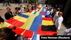 European lawmakers and Ukrainian representatives unfurl a 30-meter-long Ukrainian flag outside the EU Parliament on June 23, the day Ukraine and Moldova were given official candidate status for the bloc. 