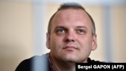 Dzmitry Halko sits in his cage in a Minsk court on July 17, 2018.