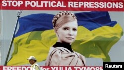 A man walks past a billboard with a portrait of jailed Yulia Tymoshenko in central Kyiv.