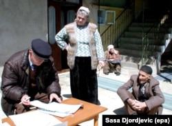 A census taker (left) talks to an ethnic Albanian family from the Serbian village of Veliki Trnovac on the Serbia-Kosovo border during a census in April 2002.