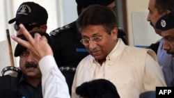 Former Pakistani President Pervez Musharraf is escorted by security personnel as he leaves the Pindi High Court after his hearing in Rawalpindi on April 17.