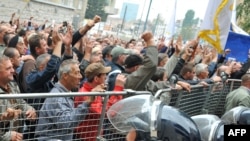 Police try to prevent angry protesters - mainly war veterans - from storming the federal parliament building. 