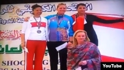 Maria Dmitrenko (top center) atop the podium following her first-place finish at the Grand Prix shooting championships in Kuwait this month.