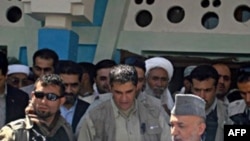 Afghan President Hamid Karzai (right) visits the village of Azizabad in early September.