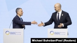 Swiss President Ignazio Cassis (left) and Ukrainian Prime Minister Denys Shmyhal shake hands at the closing plenary of the Ukraine Recovery Conference in Lugano, Switzerland, on July 5.