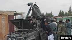 Security personnel examine the damaged vehicle belonging to Deputy Governor Abdul Latif Ashna, who was killed in the attack.