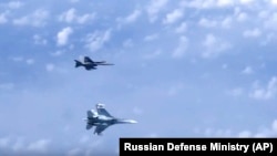 A Russian Air Force Su-27 fighter jet (bottom) maneuvers near a NATO F-18 warplane over the Baltic Sea on August 13.