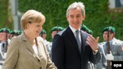 German Chancellor Angela Merkel (left) walks with Moldovan Prime Minister Iurie Leanca during a welcoming ceremony in Berlin on July 10.