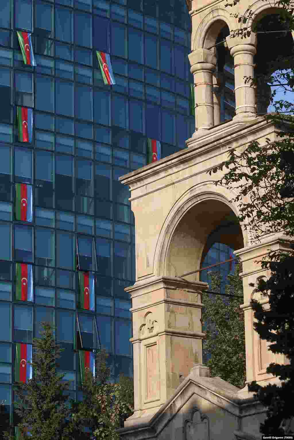 St. Gregory the Illuminator Church (right) and the offices of the International Bank of Azerbaijan are adorned with national flags on November 4.&nbsp;