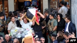 Iraqi Christians carry the coffins of those slain in the recent church attack during a funeral service at a church in Baghdad. 